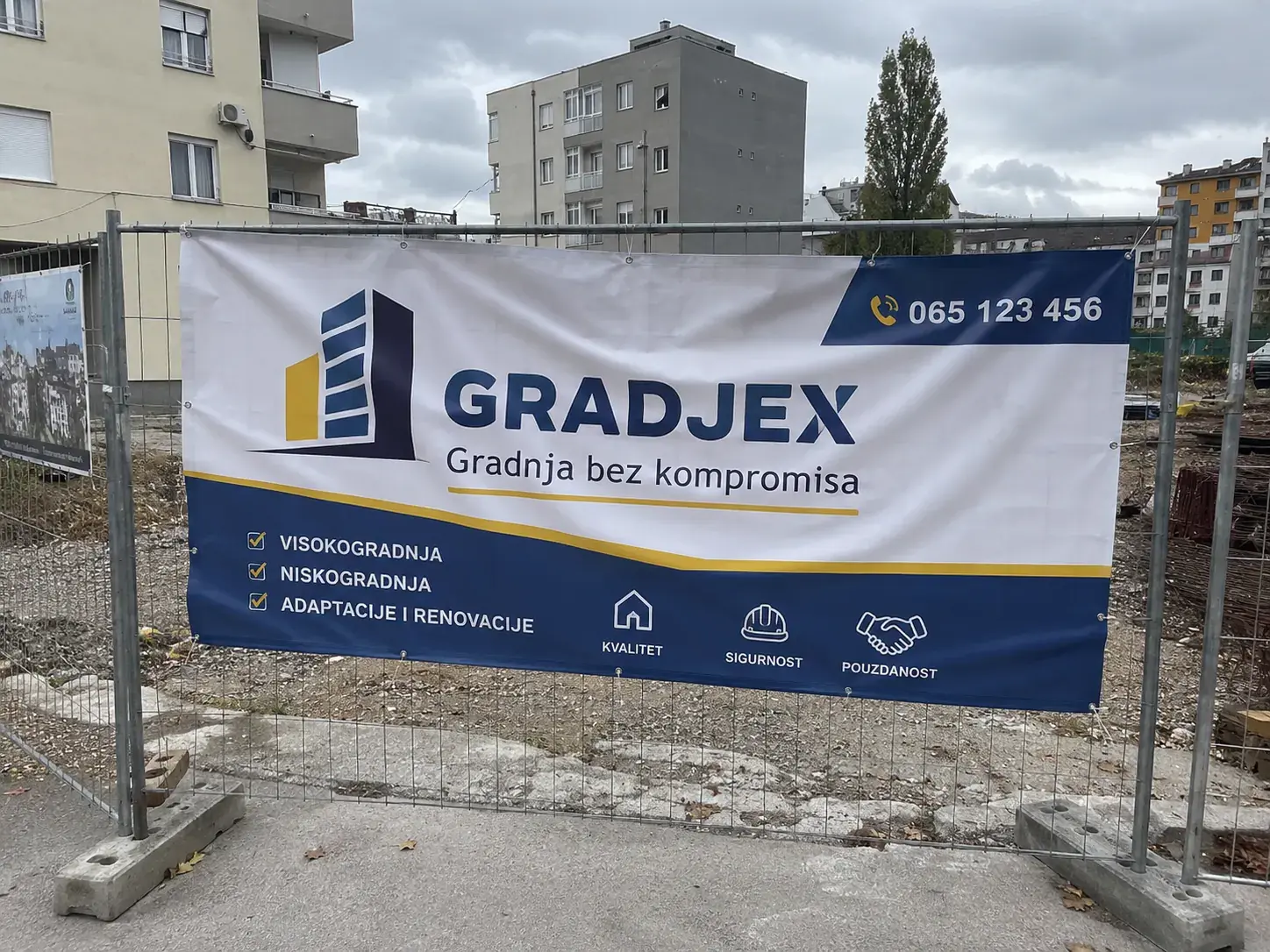 PVC banner sa brendingom firme na ogradi gradilišta sa eyeletima