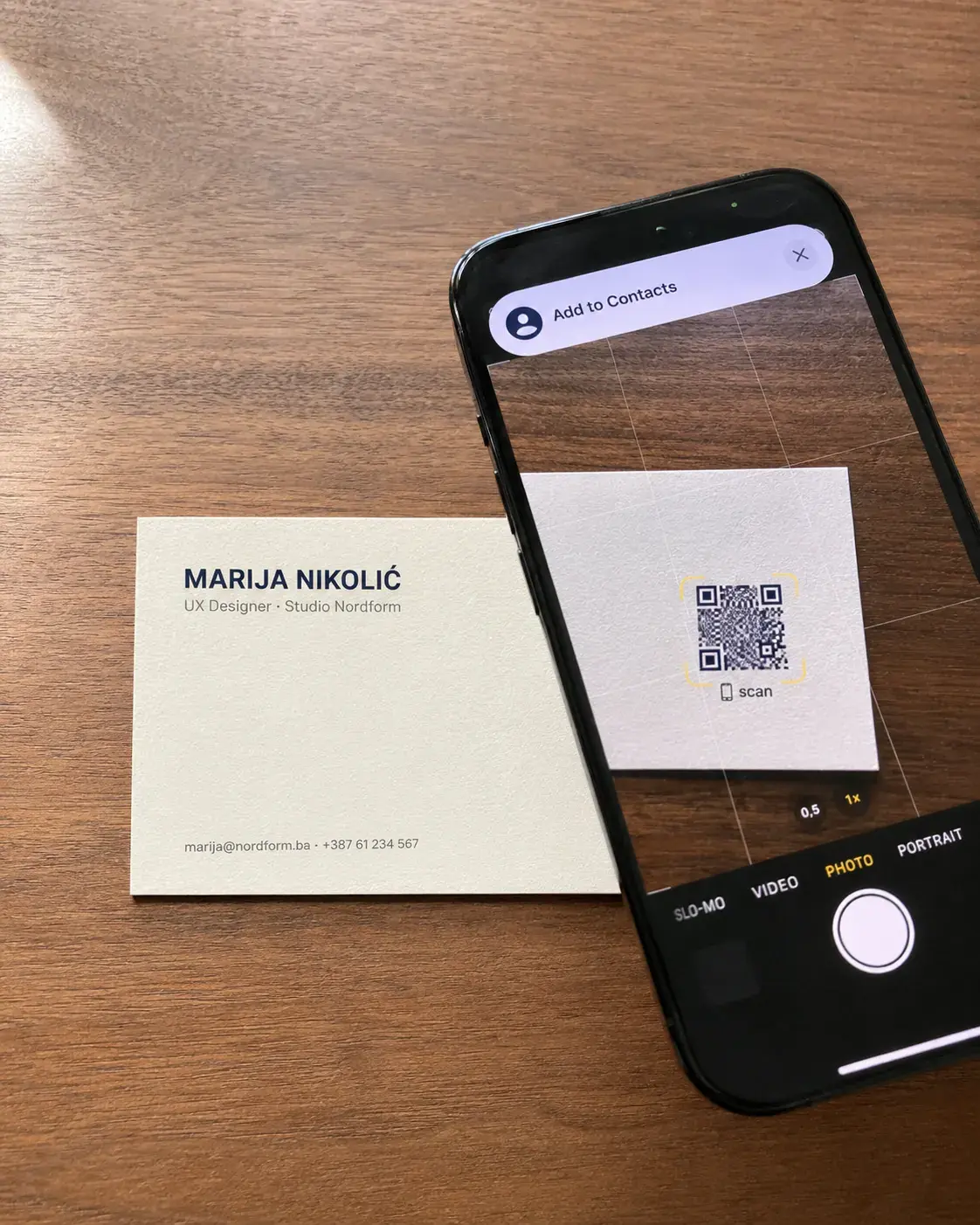 Vizit karta sa QR kodom i telefon koji sprema kontakt