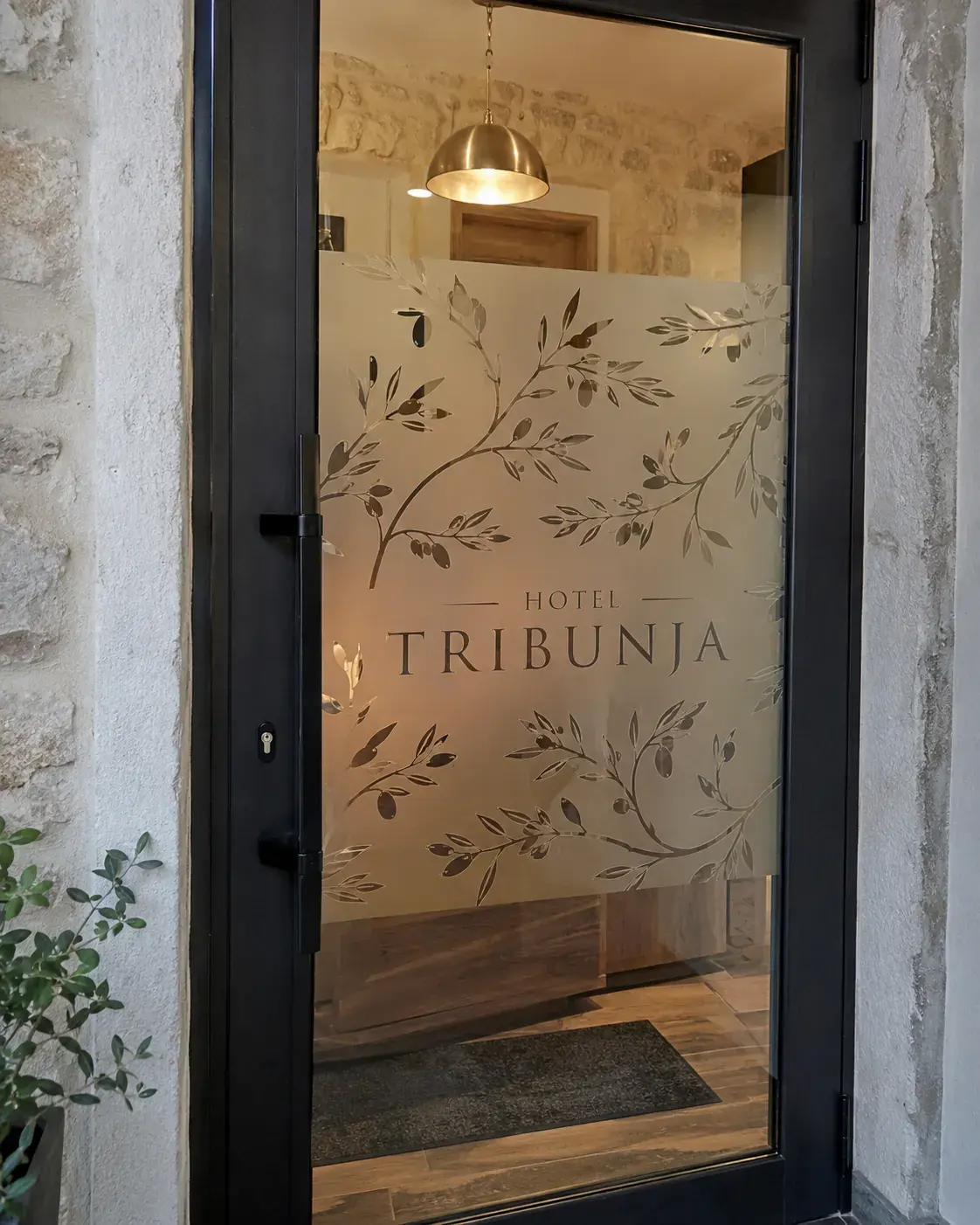 Sandblast folija sa botaničkim motivom na staklenim vratima hotela